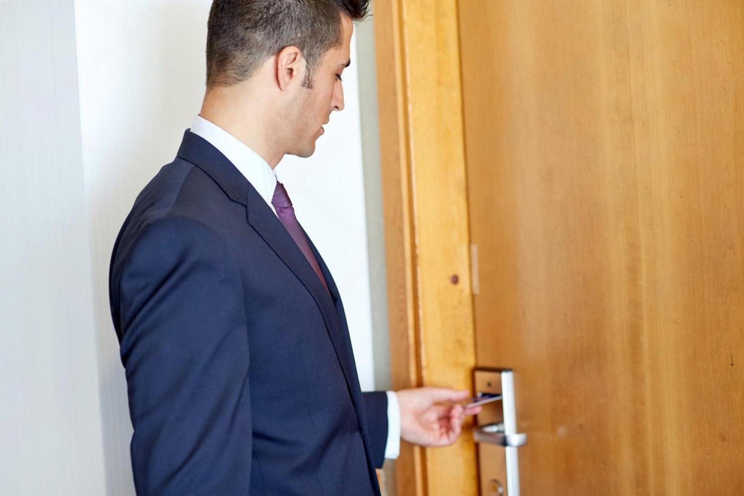 Hotel guest opening a room door with an electronic key card in a UAE hotel